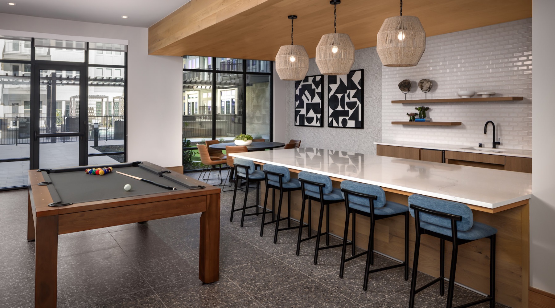 Resident lounge at The Ludlow apartments in Plano, TX, featuring counter seating and a billiards table.