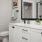 Model bathroom at our apartments for rent in Plano, TX, featuring white countertops, two sinks, and a walk in closet.