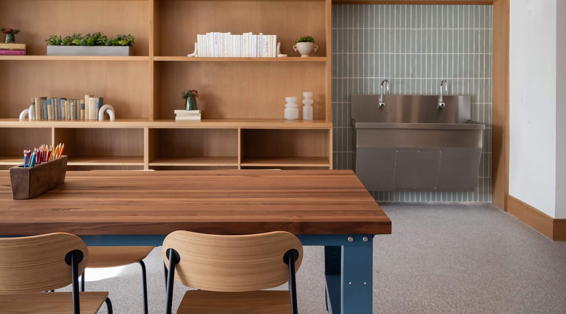 a workroom with a bookshelf and a large sink at The Ludlow in Plano, Texas.